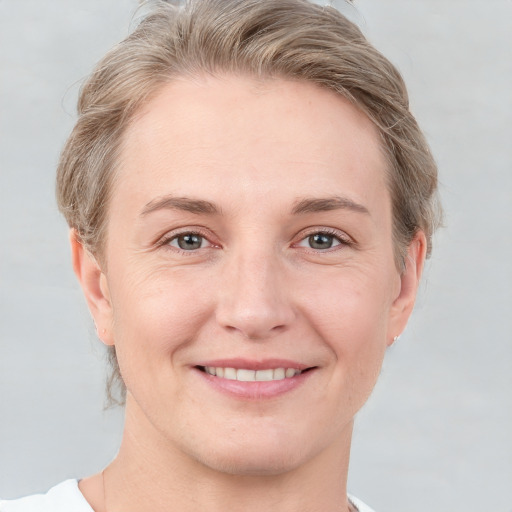 Joyful white young-adult female with short  brown hair and grey eyes