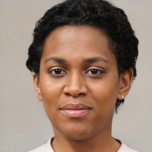 Joyful black young-adult female with short  black hair and brown eyes