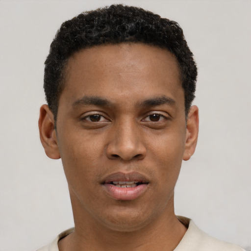 Joyful black young-adult male with short  black hair and brown eyes