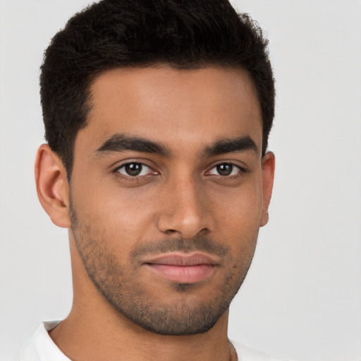 Joyful latino young-adult male with short  brown hair and brown eyes