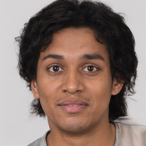 Joyful latino young-adult male with short  brown hair and brown eyes