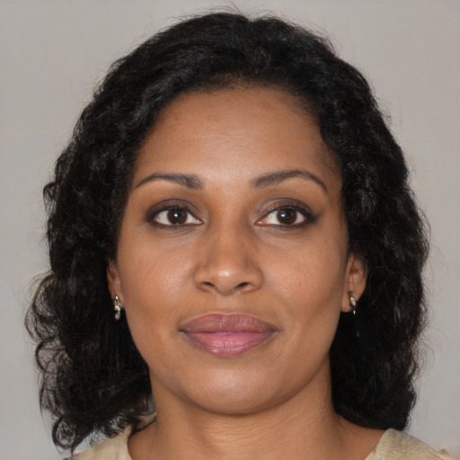 Joyful black young-adult female with medium  brown hair and brown eyes