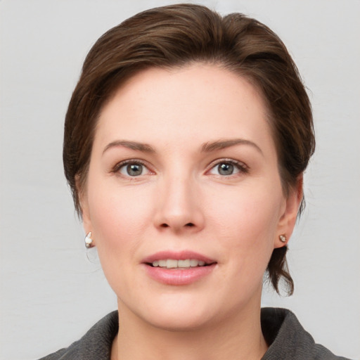 Joyful white young-adult female with medium  brown hair and grey eyes