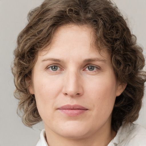 Joyful white young-adult female with medium  brown hair and green eyes