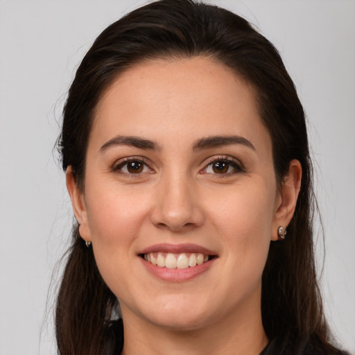 Joyful white young-adult female with long  brown hair and brown eyes