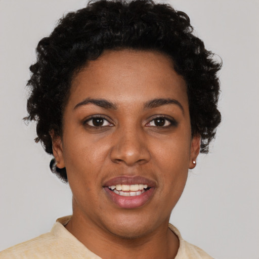 Joyful black young-adult female with short  black hair and brown eyes