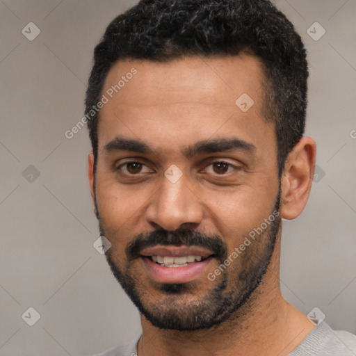 Joyful black young-adult male with short  black hair and brown eyes