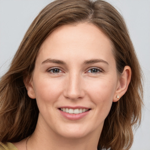 Joyful white young-adult female with long  brown hair and grey eyes