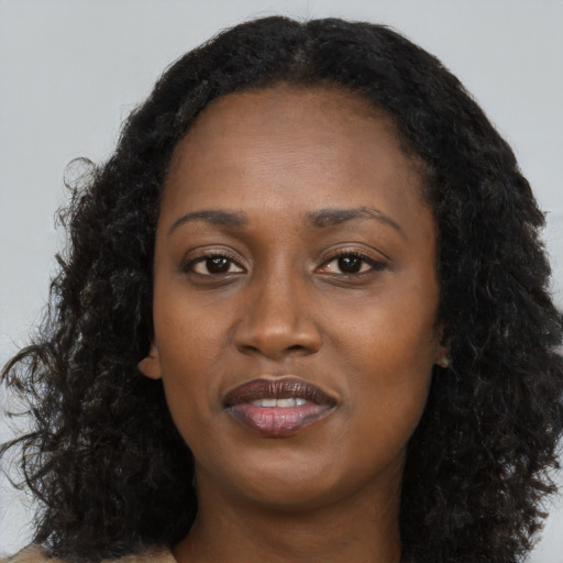 Joyful black young-adult female with long  black hair and brown eyes