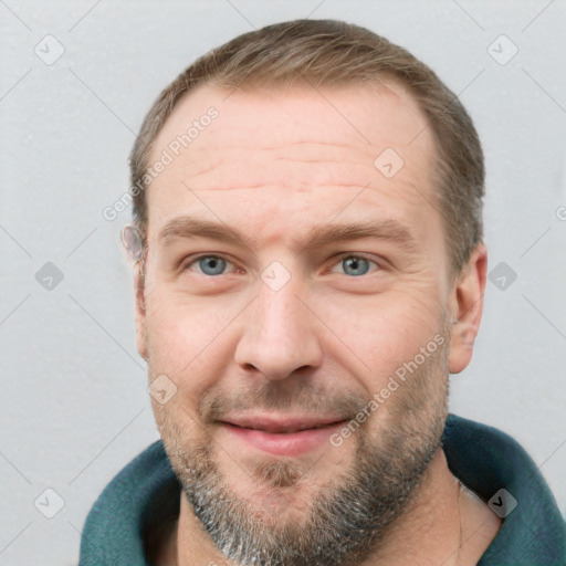 Joyful white adult male with short  brown hair and blue eyes