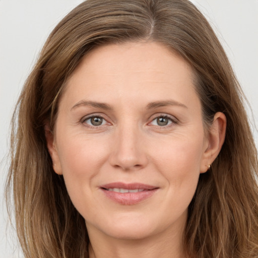 Joyful white adult female with long  brown hair and grey eyes