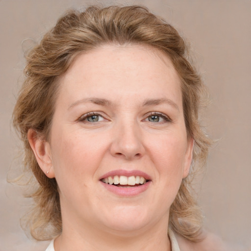 Joyful white adult female with medium  brown hair and blue eyes