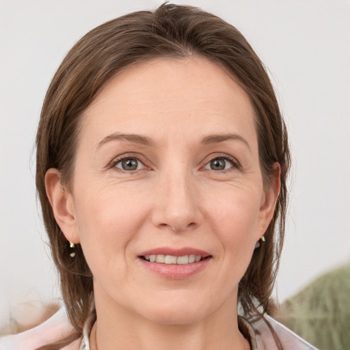 Joyful white adult female with medium  brown hair and grey eyes