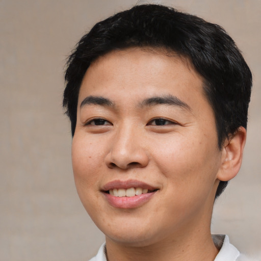 Joyful asian young-adult male with short  brown hair and brown eyes