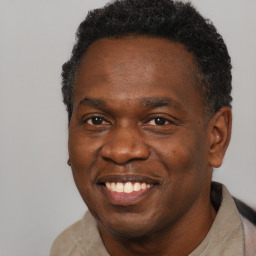 Joyful black adult male with short  black hair and brown eyes