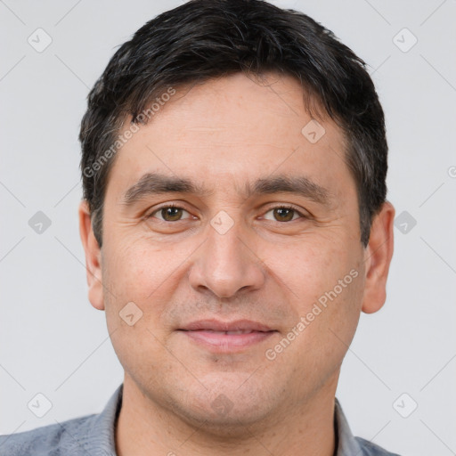 Joyful white adult male with short  black hair and brown eyes