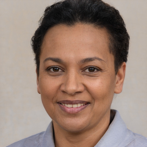 Joyful latino adult female with short  brown hair and brown eyes