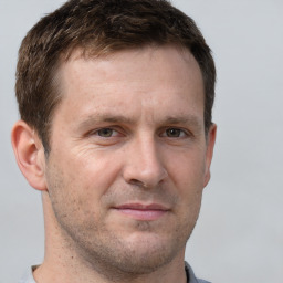 Joyful white adult male with short  brown hair and grey eyes