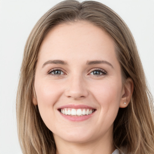 Joyful white young-adult female with long  brown hair and grey eyes