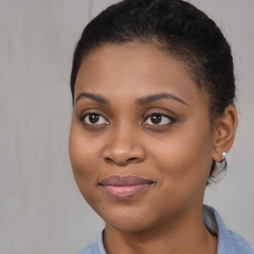 Joyful black young-adult female with short  brown hair and brown eyes