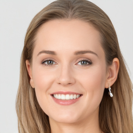 Joyful white young-adult female with long  brown hair and blue eyes