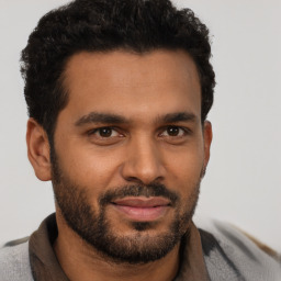 Joyful black young-adult male with short  brown hair and brown eyes