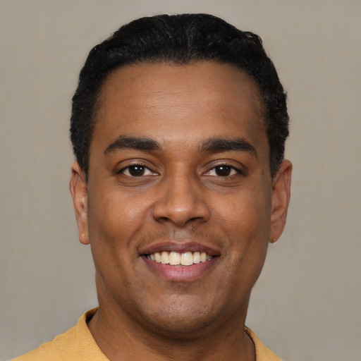 Joyful latino young-adult male with short  black hair and brown eyes