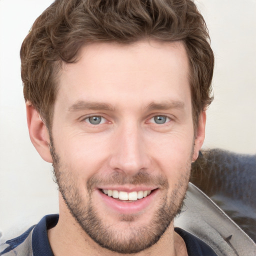 Joyful white young-adult male with short  brown hair and grey eyes