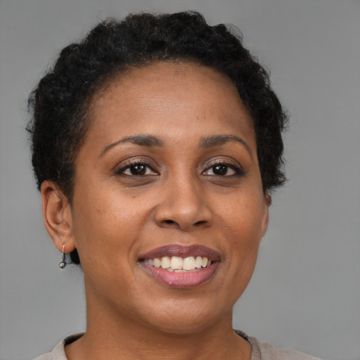 Joyful black adult female with short  brown hair and brown eyes
