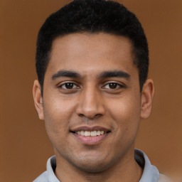 Joyful black young-adult male with short  brown hair and brown eyes