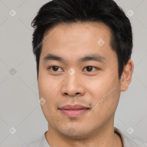 Joyful asian young-adult male with short  black hair and brown eyes