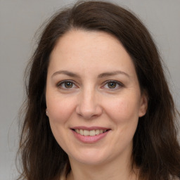 Joyful white adult female with long  brown hair and brown eyes