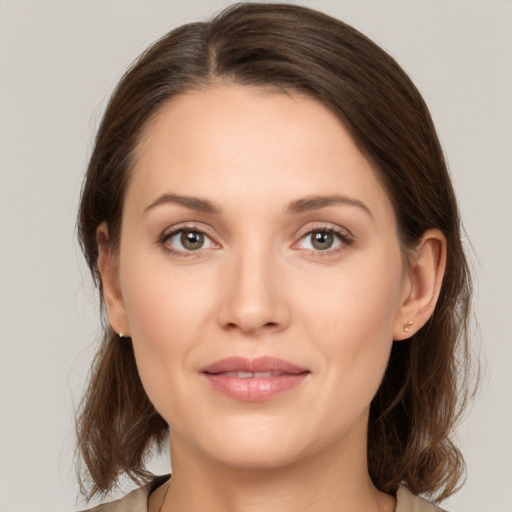 Joyful white young-adult female with medium  brown hair and grey eyes