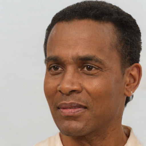 Joyful black adult male with short  black hair and brown eyes