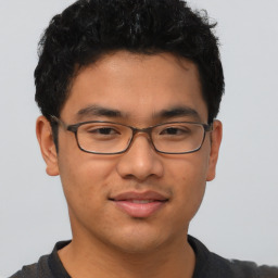 Joyful latino young-adult male with short  brown hair and brown eyes