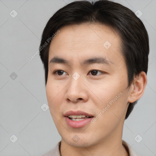 Joyful asian young-adult male with short  brown hair and brown eyes