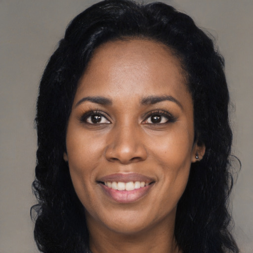 Joyful black young-adult female with long  black hair and brown eyes