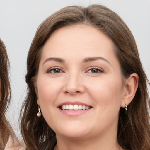 Joyful white young-adult female with long  brown hair and grey eyes