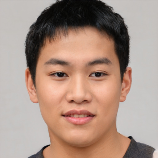 Joyful asian young-adult male with short  black hair and brown eyes