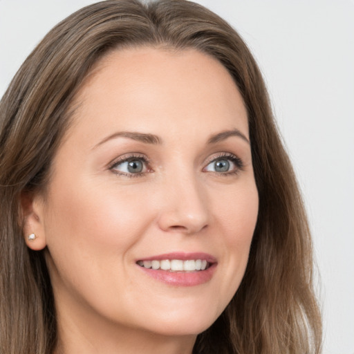 Joyful white young-adult female with long  brown hair and grey eyes