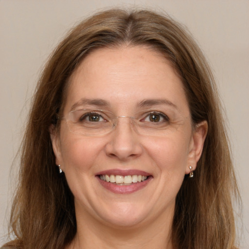 Joyful white adult female with long  brown hair and green eyes