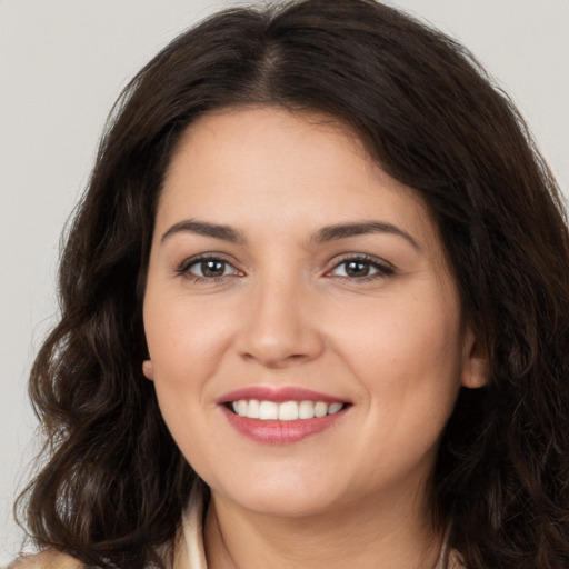 Joyful white young-adult female with long  brown hair and brown eyes