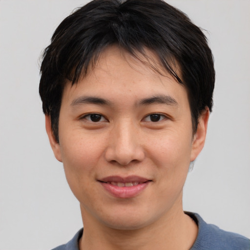 Joyful asian young-adult male with short  black hair and brown eyes