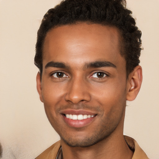 Joyful black young-adult male with short  brown hair and brown eyes