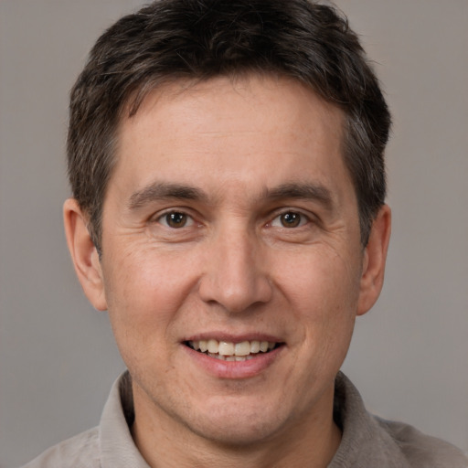 Joyful white adult male with short  brown hair and brown eyes