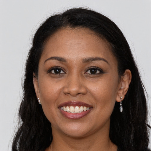 Joyful black young-adult female with long  brown hair and brown eyes