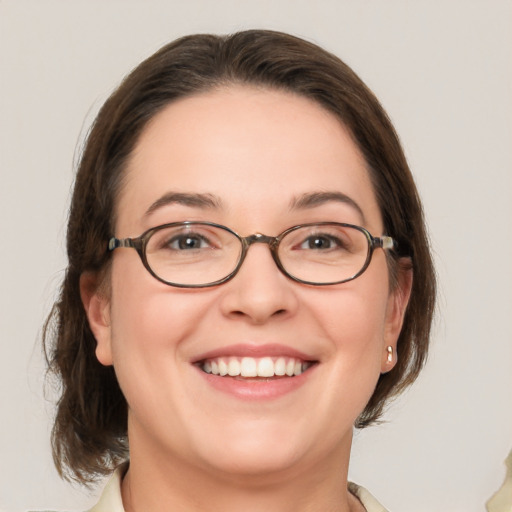 Joyful white adult female with medium  brown hair and green eyes