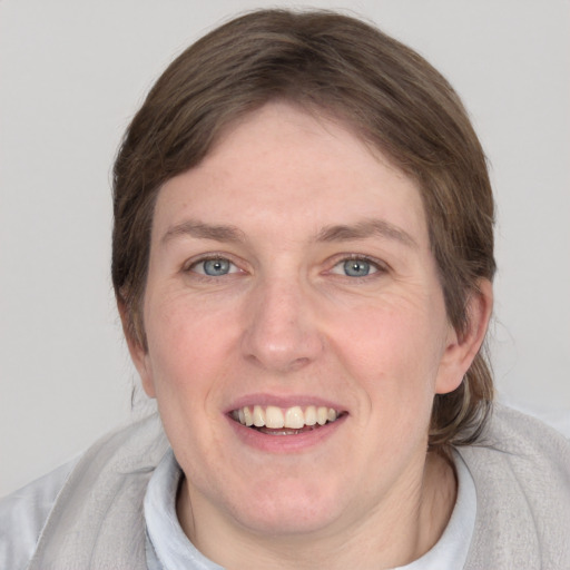 Joyful white adult female with medium  brown hair and grey eyes