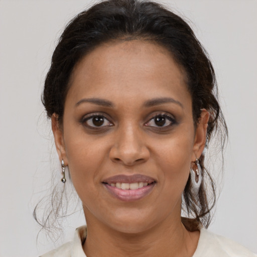 Joyful black adult female with medium  brown hair and brown eyes