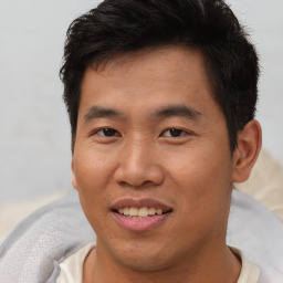 Joyful asian young-adult male with short  brown hair and brown eyes